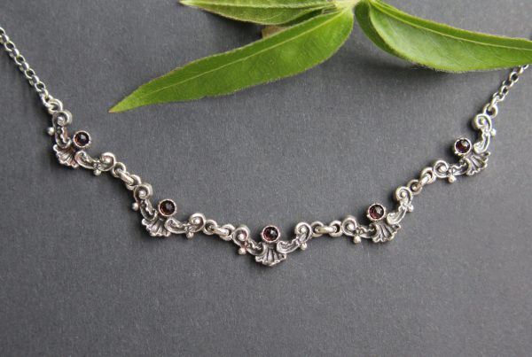 Trachtenkette für Damen: Silberne, zierliche Halskette zum Dirndl mit kleinen Granat Schmucksteinen