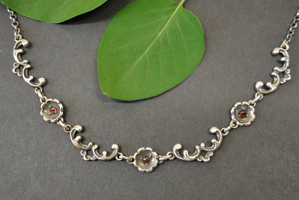 Trachtenschmuck Trachtenkette Beate aus Silber mit kleinen Blumen und drei Steinchen aus Granat