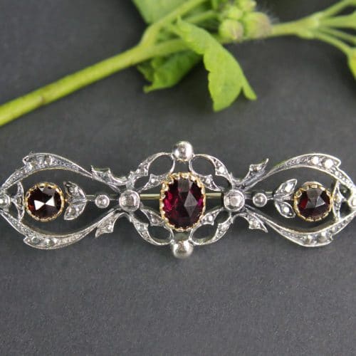 Längliche Trachten Brosche in SIlber mit Granat und kleinen blumigen Details