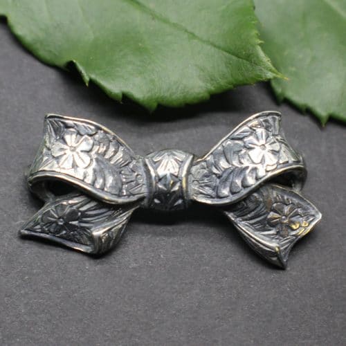 Trachtenschmuck Brosche in Silber, Form Schleife mit Blumenmuster