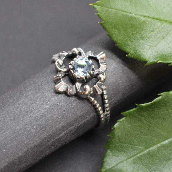 Seitliche Ansicht des Trachtenschmuck Rings in Silber. Der Ring ist mit synthetischem Spinell, einem hellblauen Edelstein gefasst. In den gängigsten Ringgrößen erhältlich.