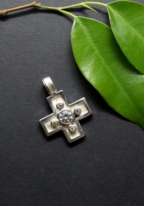 Modernes, silbernes Kreuz mit vier kleinen und einem großen Zirkonia gefasst