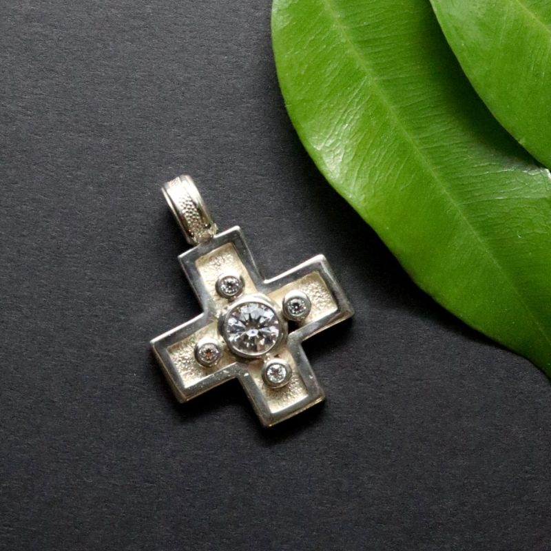 Modernes, silbernes Kreuz mit vier kleinen und einem großen Zirkonia gefasst